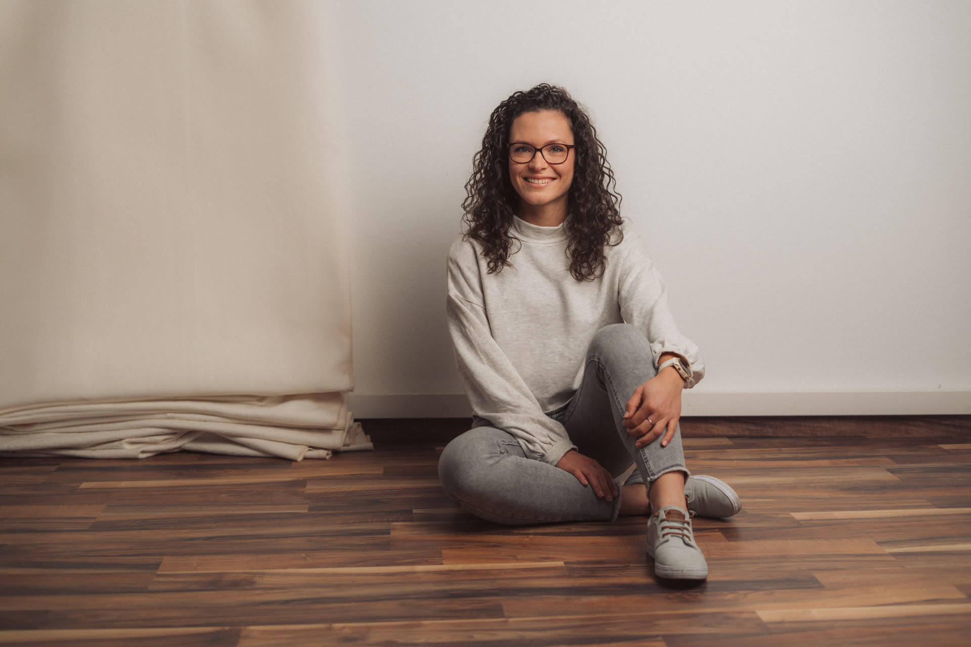Nora sitzt lächelnd in ihrem Trainingsraum